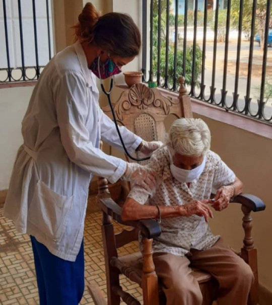 Cuban student Gabriela Reguera checks her grandmother (with whom she lives) for respiratory symptoms.