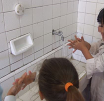 Fotograf&iacute;a de estudiantes de la escuela p&uacute;blica ensayando la pr&aacute;ctica correcta del lavado de manos