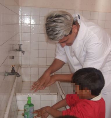 Momento de trabajo pr&aacute;ctico en los sanitarios. Fotograf&iacute;a de estudiante de la escuela p&uacute;blica ensayando la pr&aacute;ctica correcta del lavado de manos.