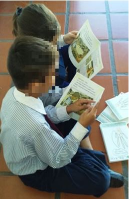 Taller cuenta cuentos y juegos. Fotograf&iacute;a de estudiantes de la escuela privada utilizando el libro infantil: Manos limpias. Ni&ntilde;os m&aacute;s sanos (Oberto et al., 2016).