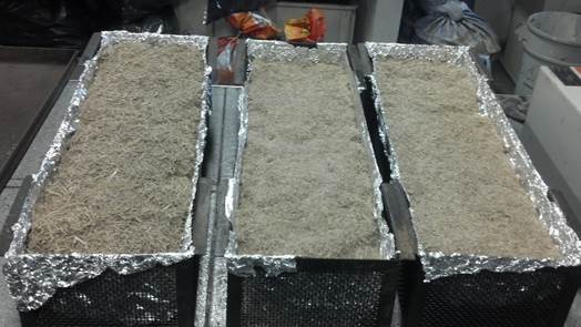 Bamboo and sugarcane bagasse particles, packed into containers with dimensions of 13 cm x 18 cm x 58 cm (height x width x length), internally lined with aluminum foil, for insertion in an oven and application of the heat treatment.