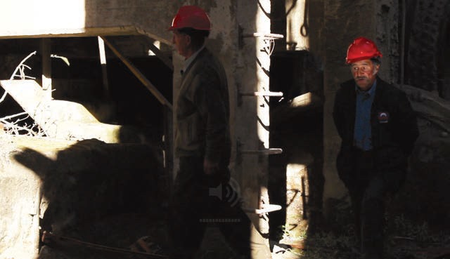 Fotograma de La Siberia: dos personajes caminando por
un claroscuro al interior de las ruinas.