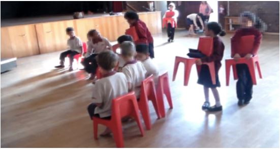 Walking into the hall with their chairs to create a circle