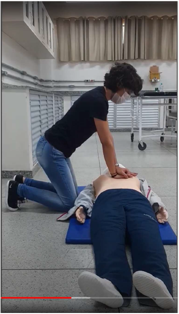 Figura 3 - Trecho da videoaula em que extensionista demonstra as manobras de RCP em manequim