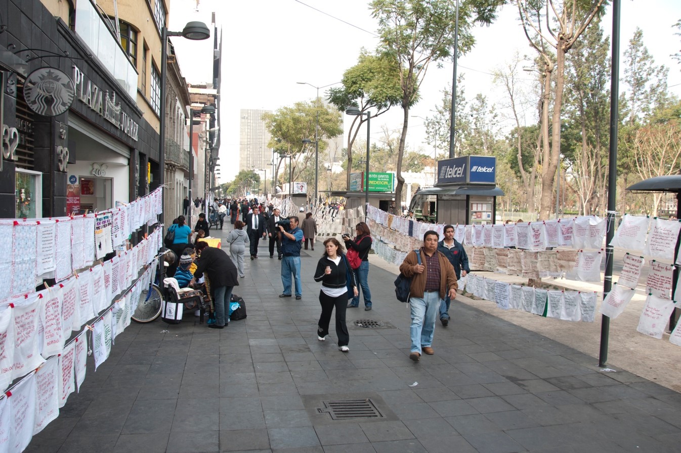 Bordados por la Paz. Pañuelos realizados por personas de distintas ciudades de México que bordan los nombres de los desaparecidos y asesinados desde el sexenio de Calderón. Fueron expuestos en la calle Juárez del Centro Histórico de la Ciudad de México, el 1ro de diciembre de 2012.