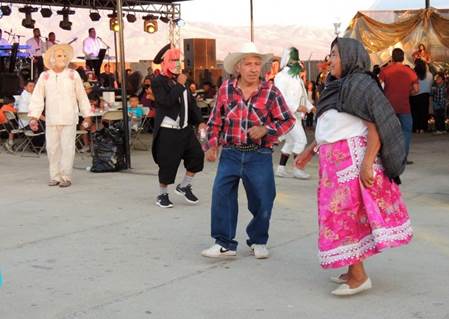 Los disfrazados y algunos miembros del público bailando chilenas durante la fiesta de San Juan Bautista en Bakersfield, California