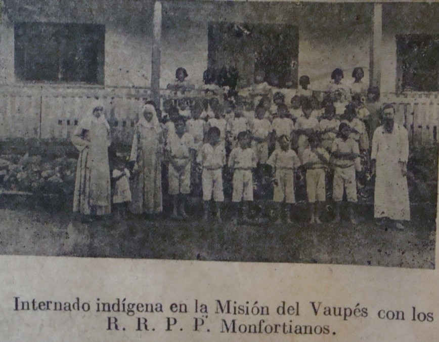 En la imagen se aprecian adelante los alumnos y atrás las alumnas todos ellos con su uniforme. Al lado izquierdo hay dos religiosas lauritas y a la derecha un misionero montfortiano (probablemente Alfonso Cuypers).