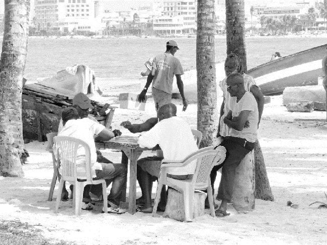 Pescadores y amigos jugando dominó en la playa de la cooperativa.