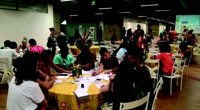 Foto 2. Mesa de trabalho com tema da &ldquo;Cultura&rdquo; (nos fundos, a esquerda, a mesa anterior em que est&atilde;o membros de povos e comunidades tradicionais)