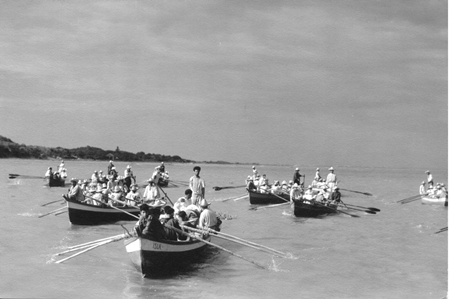 Ned Scott, foto fija, pescadores unidos atraviesan el río con el cuerpo de Miro. Reproducida con autorización del Archivo Ned Scott. 