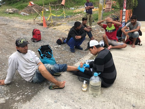 Art For Impact co-founder, Nery Santaella, cleans and bandage blisters for a group of Venezuelan youth who have been walking several days over the mountain passes between Cucuta and Bogota.
