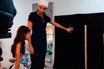 Fotografía que muestra a la Dra. Verónica Morris dándole las instrucciones a una de las voluntarias de este estudio, en el set fotográfico. Tanto la paciente como su tutor legal autorizaron la publicación de esta fotografía.