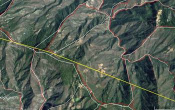 Detalle comparativo de la rodalizaci&oacute;n: sobre una imagen de Google Earth con t&eacute;cnicas fotogram&eacute;tricas (color rojo) y el m&eacute;todo semiautomatizado basado en el an&aacute;lisis geomorfom&eacute;trico de superficies a partir del MDE-Inegi (color blanco); en amarillo el l&iacute;mite de predio.