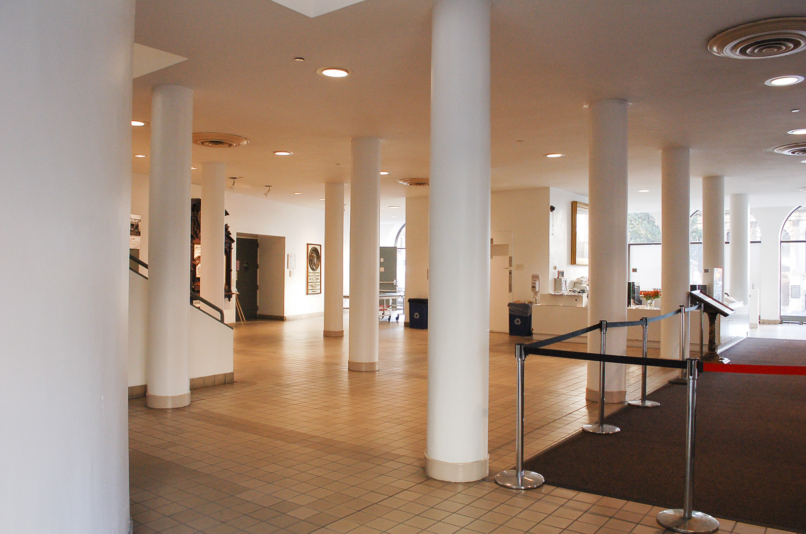 Fotograf&iacute;a desde la esquina suroeste de la planta baja del vest&iacute;bulo de la
                  Cooper Union. En primer plano est&aacute; la curva del cilindro del elevador.
                