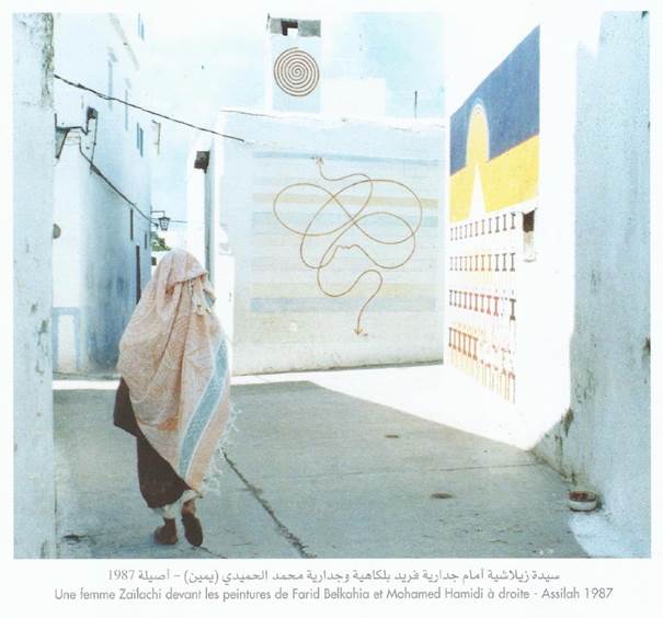 A woman of Asilah in front of murals by Farid Belkahia and Mohamed Hamidi right Asilah 1987 Image reproduced from the book Peinture murale d’Asilah Evasions dans l’imaginaire by the Fondation du Forum d’Asilah p 70