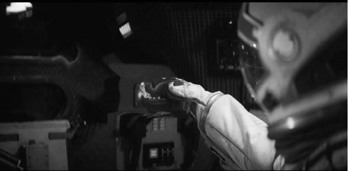 Deforma&ccedil;&atilde;o da m&atilde;o da Dra. Brand devido &agrave; anomalia gravitacional dentro da nave, ao atravessarem um buraco de minhoca