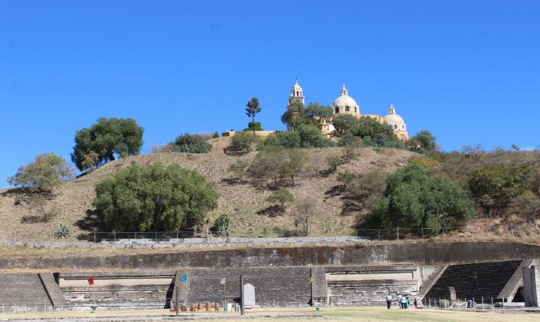The pyramid at Cholula with the church of Los Remedios at its summit
                            and with drums readied for the winter solstice dance.