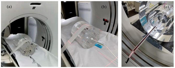 Experimental setup used in clinical measurements, showing the head  phantom in the gantry of a GE HD750 clinical CT scanner, illustrating the  irradiation (a) of the OSL strips (inside black opaque  plastic straws) and (b) of the ionization chamber (in the central  hole). In (c), the irradiation of an OSL strip in air,  showing the chest phantom. Positioning was achieved with the help of the CT  lasers.