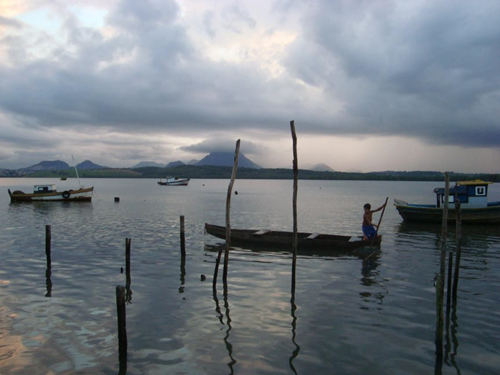CRIAN�A BRINCANDO COM A CANOA E AO FUNDO O MONTE MOXUARA NO MUNIC�PIO DE CARIACICA, VIT�RIA, ES.