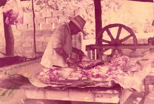 Campesino preparando la carne de cerdo asada en la dcada de los 80.