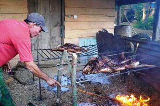 Campesino preparando la carne de cerdo asada en la actualidad.