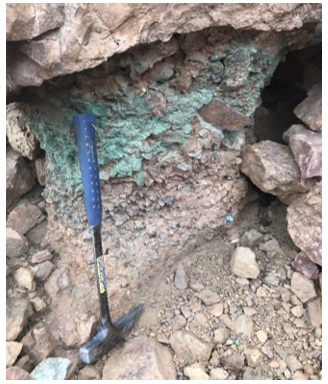 Fotograf&iacute;a en uno de los afloramientos del conglomerado del Mioceno mostrando mineralizaci&oacute;n de cobre en forma de malaquita cubriendo parte de los fragmentos de roca.