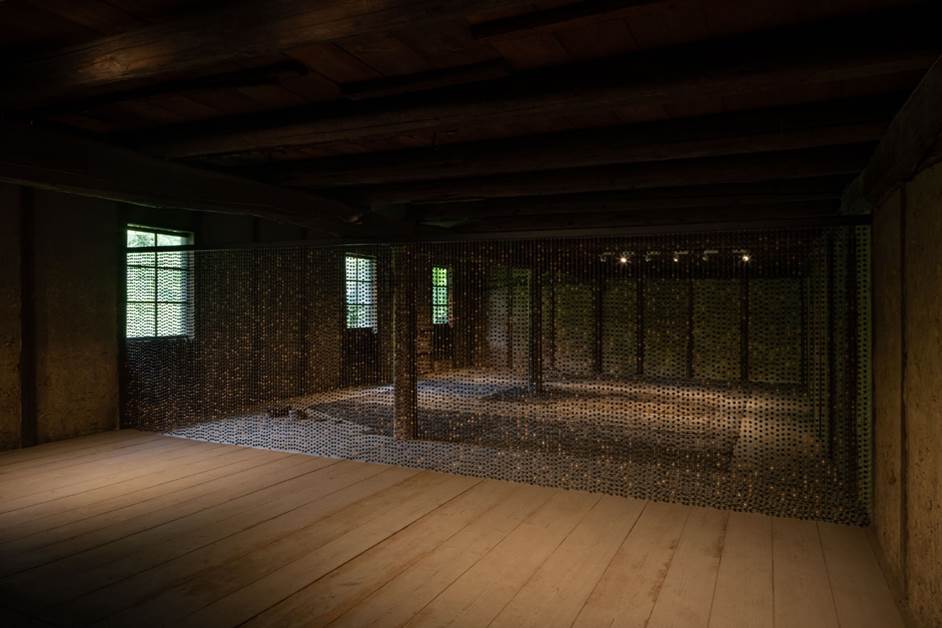 Florencia Sadir, Lluvia de barro. 2022. 12.000 cuentas de cer&aacute;mica negra, hilo de chaguar. 600 x 180 cm. Atr&aacute;s, ceniza de paja de arroz y de cascarillas de arroz. Tokoname, Jap&oacute;n