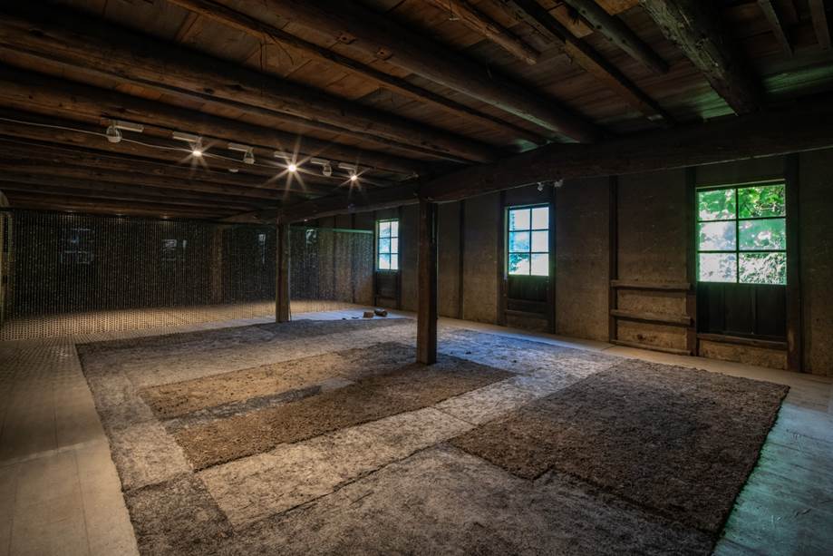 Florencia Sadir, Lluvia de barro. 2022. 12.000 cuentas de cer&aacute;mica negra, hilo de chaguar. 600 x 180 cm. Atr&aacute;s, ceniza de paja de arroz y de cascarillas de arroz. Tokoname, Jap&oacute;n