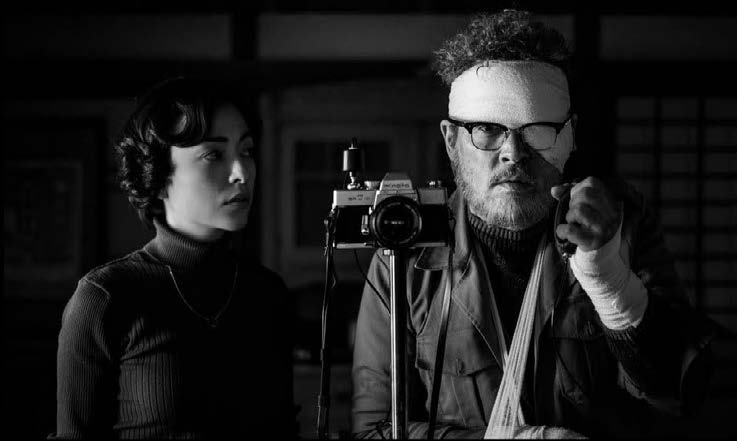 Eugene Smith, quebrado pela surra que o cegou e quase o deixou aleijado, adapta seu equipamento fotogr&aacute;fico para conseguir realizar a foto com ajuda de Aileen 