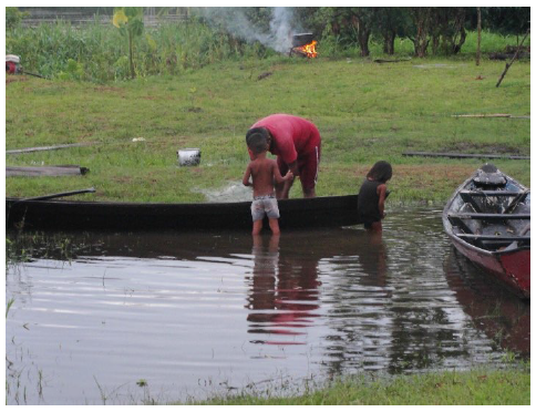 Crian&ccedil;as brincando na canoa e a m&atilde;e de uma delas acompanhando