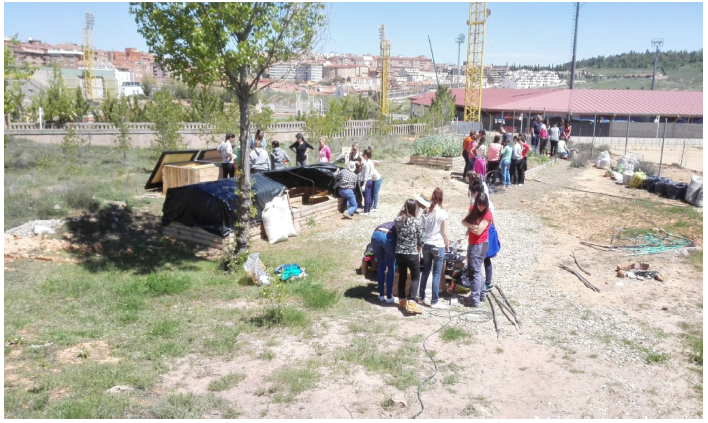 Jornada de trabajo en el huerto. Los
diferentes grupos de estudiantes trabajan en relaci&oacute;n a la zona de plantas
compa&ntilde;eras (fondo), compostero (izquierda), vermicompostero (centro),
semilleros (derecha primer plano) y bancales elevados (derecha segundo plano).
Fuente: Elaboraci&oacute;n propia.