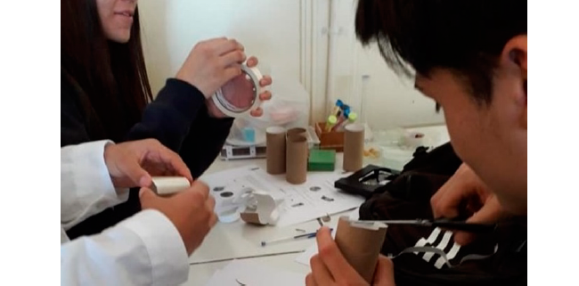 Estudiantes construyendo el modelo de microscopio.