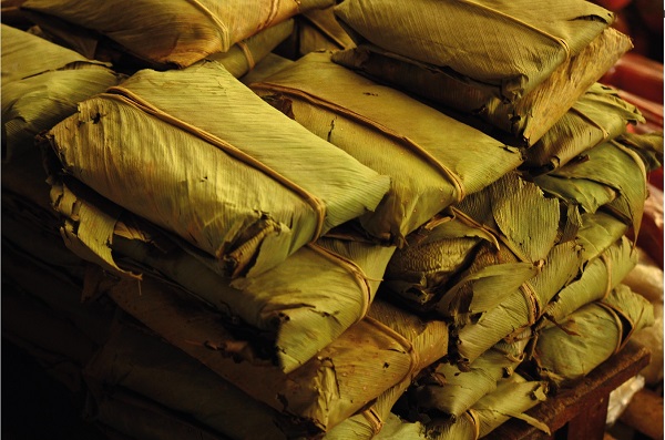 Assorted foods are packaged and served in banana leaves. Silvia, Colombia.